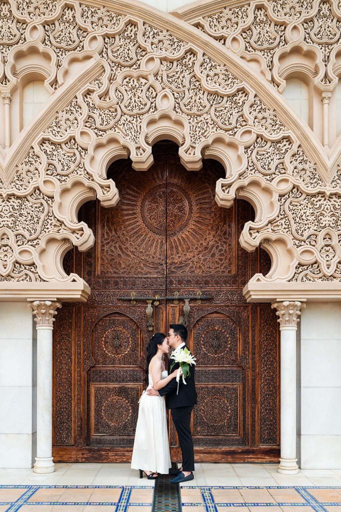 Couple de mariés devant une porte ornée